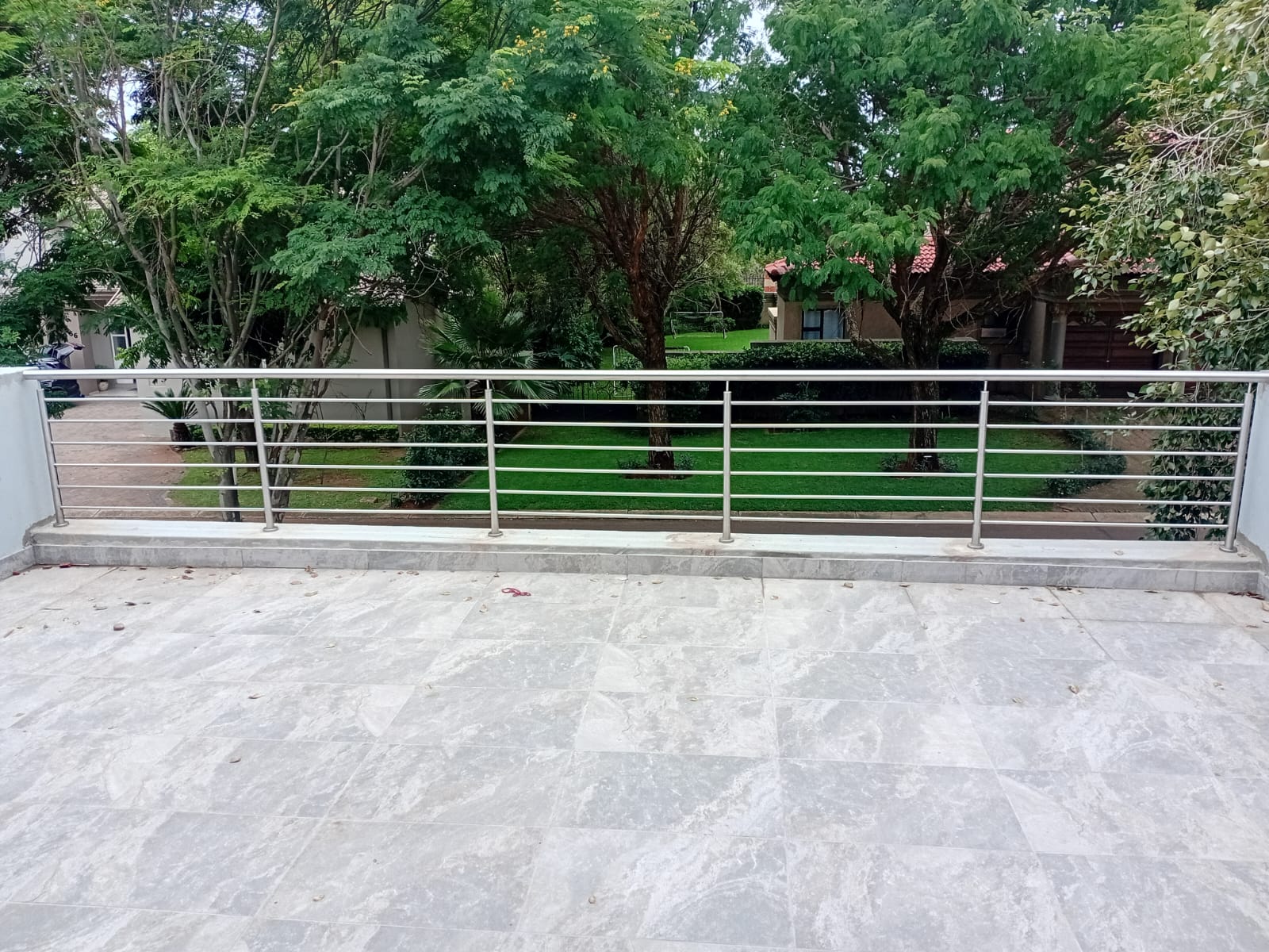 Classic horizontal stainless-steel balcony balustrade overlooking a garden