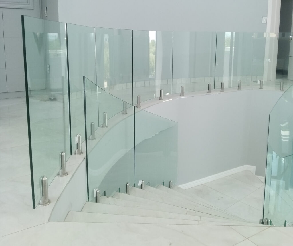 Curved frameless glass balustrade mounted with stainless-steel spigots
